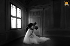 At Palazzo Te in Mantova, Italy, a couple shares a romantic dip in an empty room. Captured in black and white, natural window light accentuates their intimacy and creates a timeless, elegant portrait.